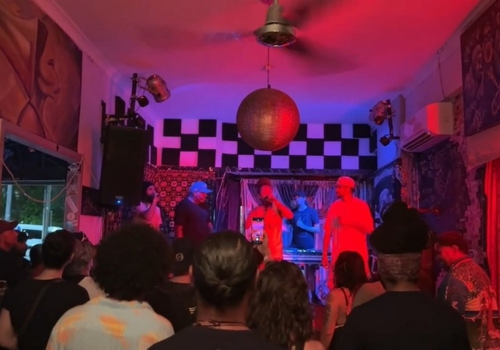 Crowd in a club with a disco ball above the stage